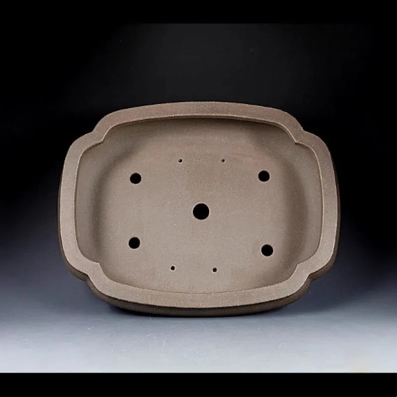 Handmade antique purple clay papaya-shaped flower pot on a wooden surface.