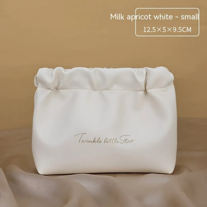 Leather travel toiletry bag in caramel mocha colour showing storage compartments and decorative letter details