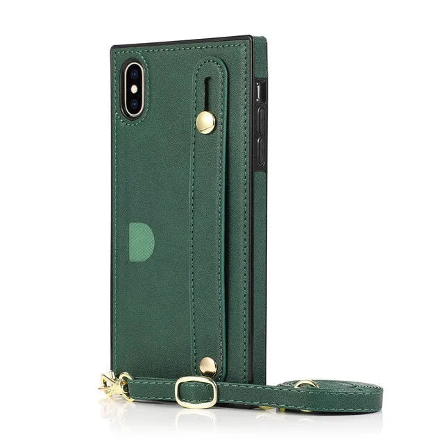 Black leather iPhone case with card holder slot and detachable wrist strap on a table