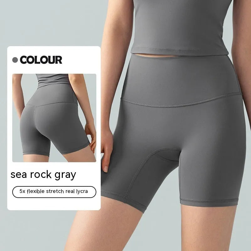 Women's high waist Lycra yoga shorts in leaf green, shown in a yoga pose.