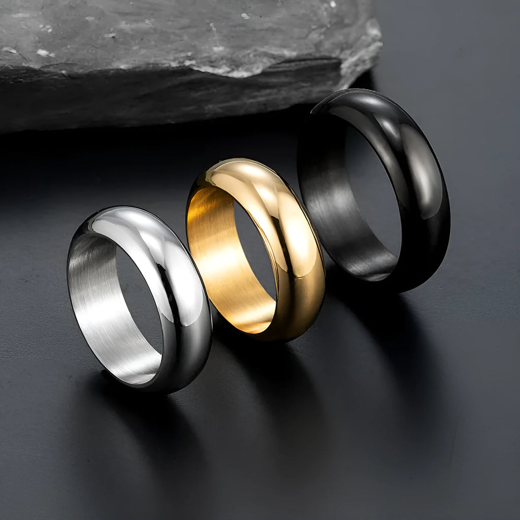 Glossy electroplated titanium steel ring shown in gold, black, and steel colour finishes on a grey background.