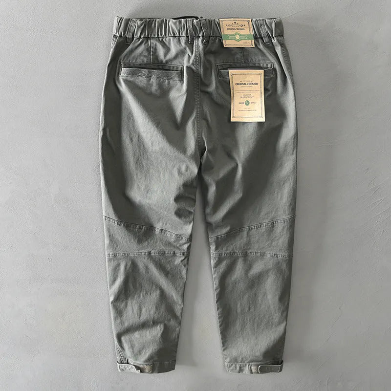 Men's khaki coloured loose-fit casual overalls with an elastic waistband on a hanger.