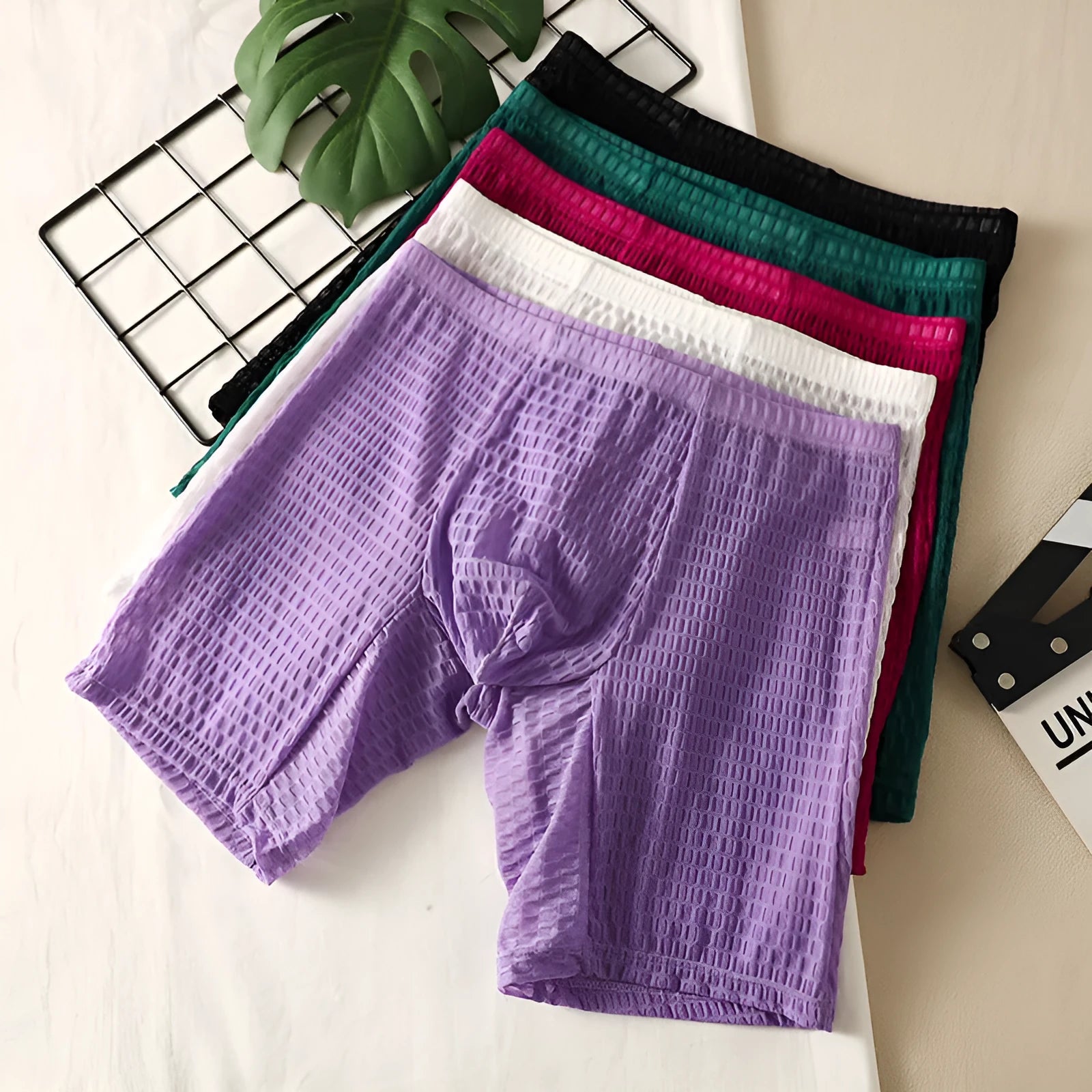 Men's solid colour lace boxers with a lengthened hip-lifting shaping design on a size chart.