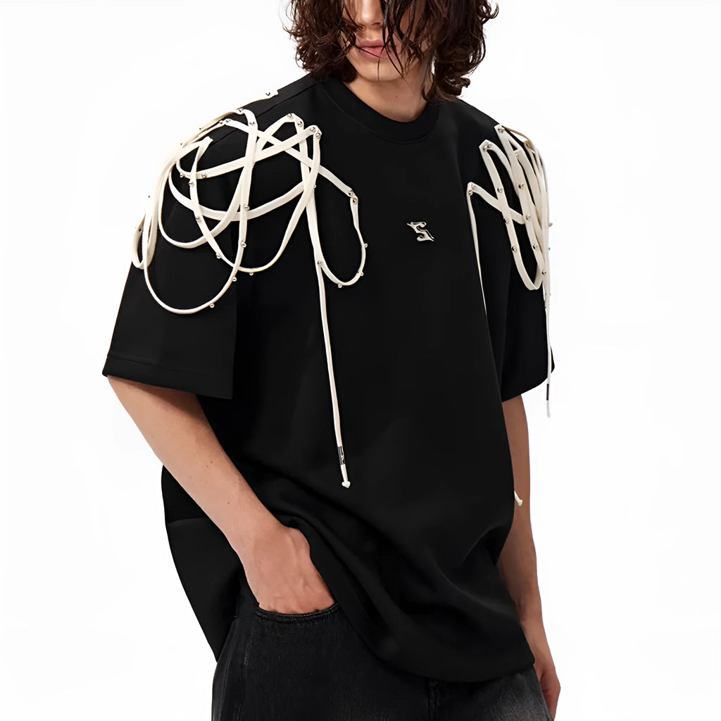 Black loose fit short sleeve T-shirt with ribbon and rivet decorated padded shoulders.