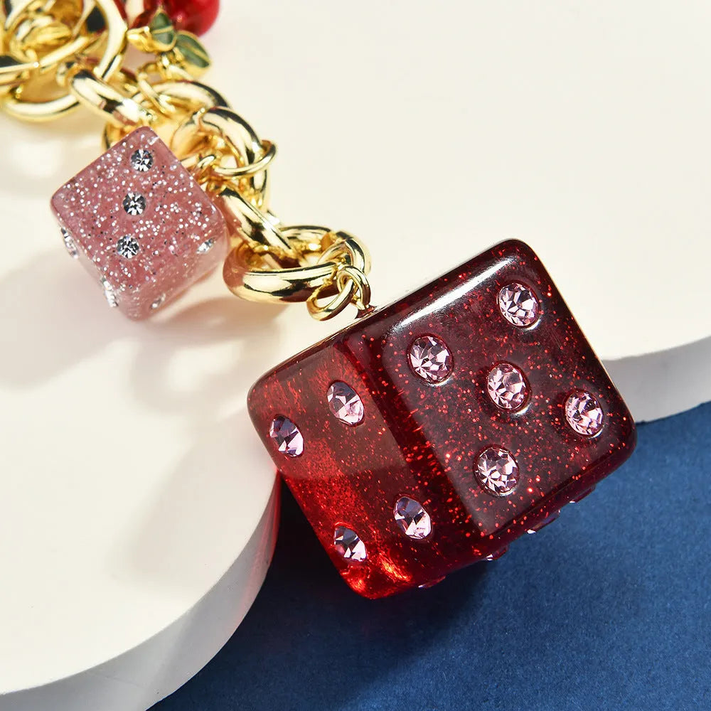 Square metal keychain pendant with a vintage two-tone cherry dice pattern on a white background.