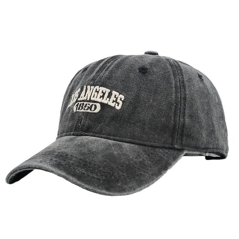 Retro washed distressed embroidered peaked cap with adjustable strap on a conical crown.