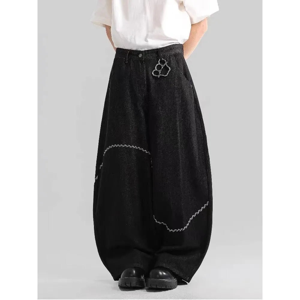 Men's black straight-leg denim trousers with a zip fly on a mid waist, shown in a casual street style.