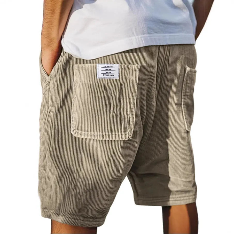 Men's grey corduroy shorts with embroidered detail on multiple pockets, laid flat.