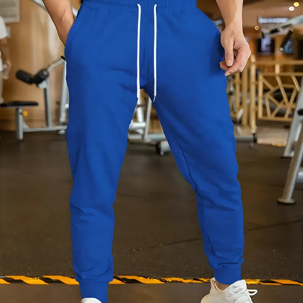 Men's loose fit linen-style trousers with a drawstring elastic waist, shown in a casual setting.