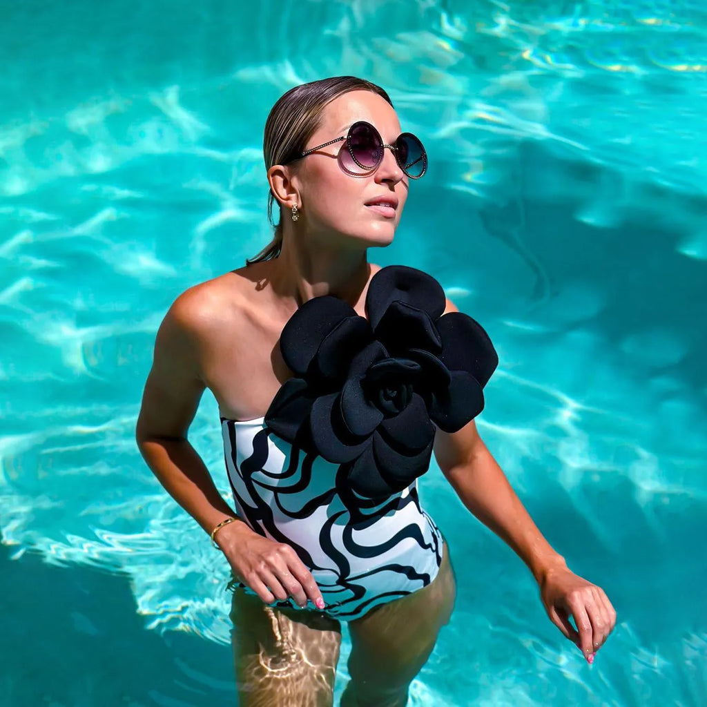 Close-up of a solid colour one-piece swimsuit with raised three-dimensional flower pattern detail