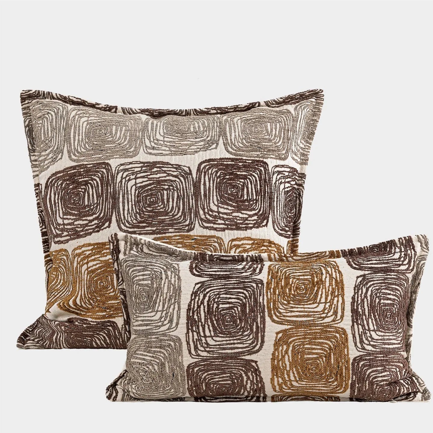 Cream and coffee coloured abstract coil pattern on two pillow sizes: a square cushion and a rectangular bolster.