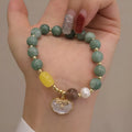 Green jade bracelet with carved shell charm and adjustable silver-tone clasp