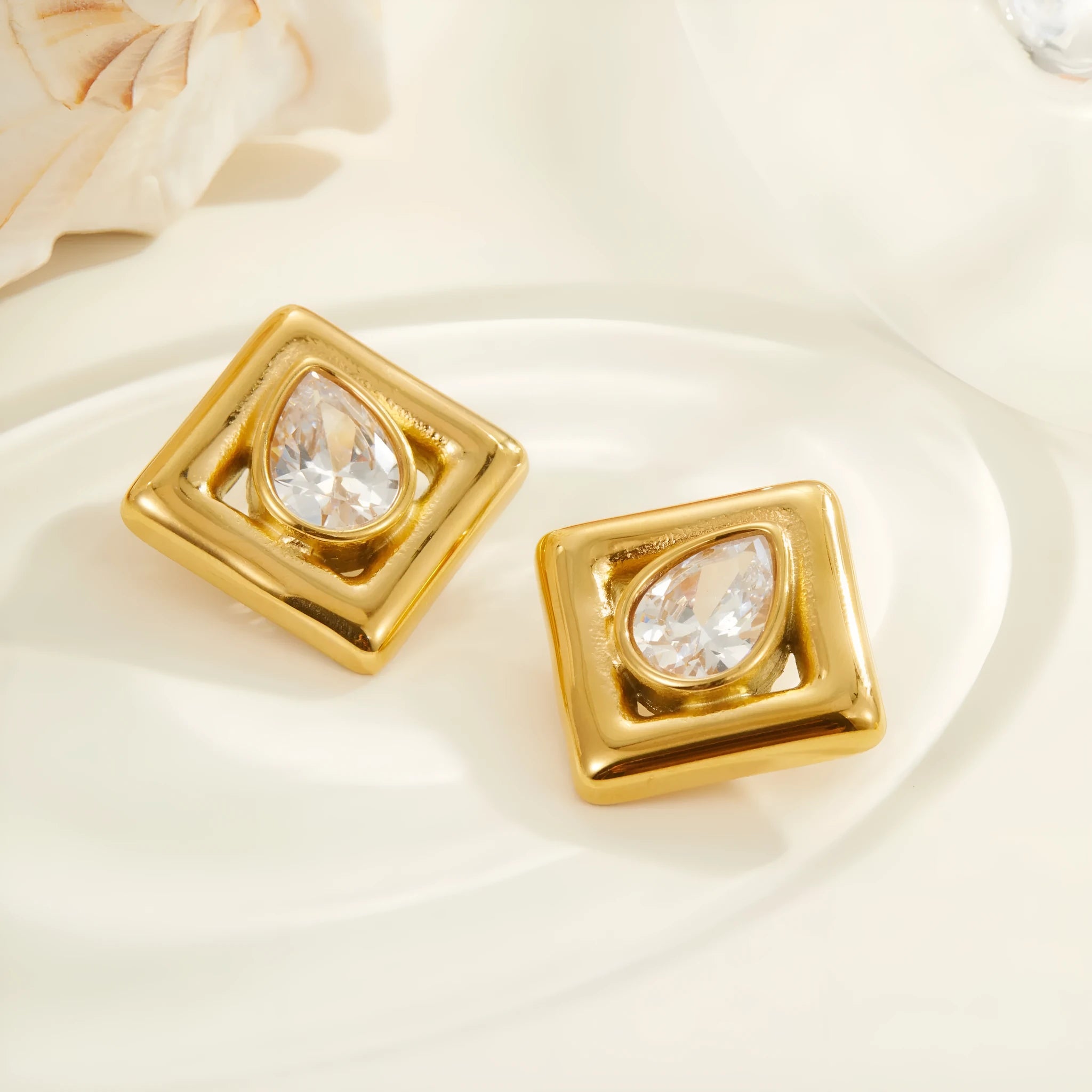Gold geometric stud earrings for women with inlaid water drop shaped zircon stones.