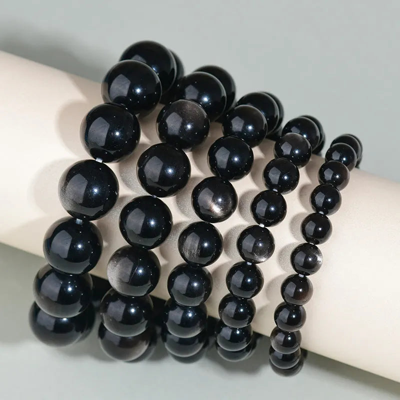 Hand-woven obsidian bracelet with round beads and engraved birth year detail for couples