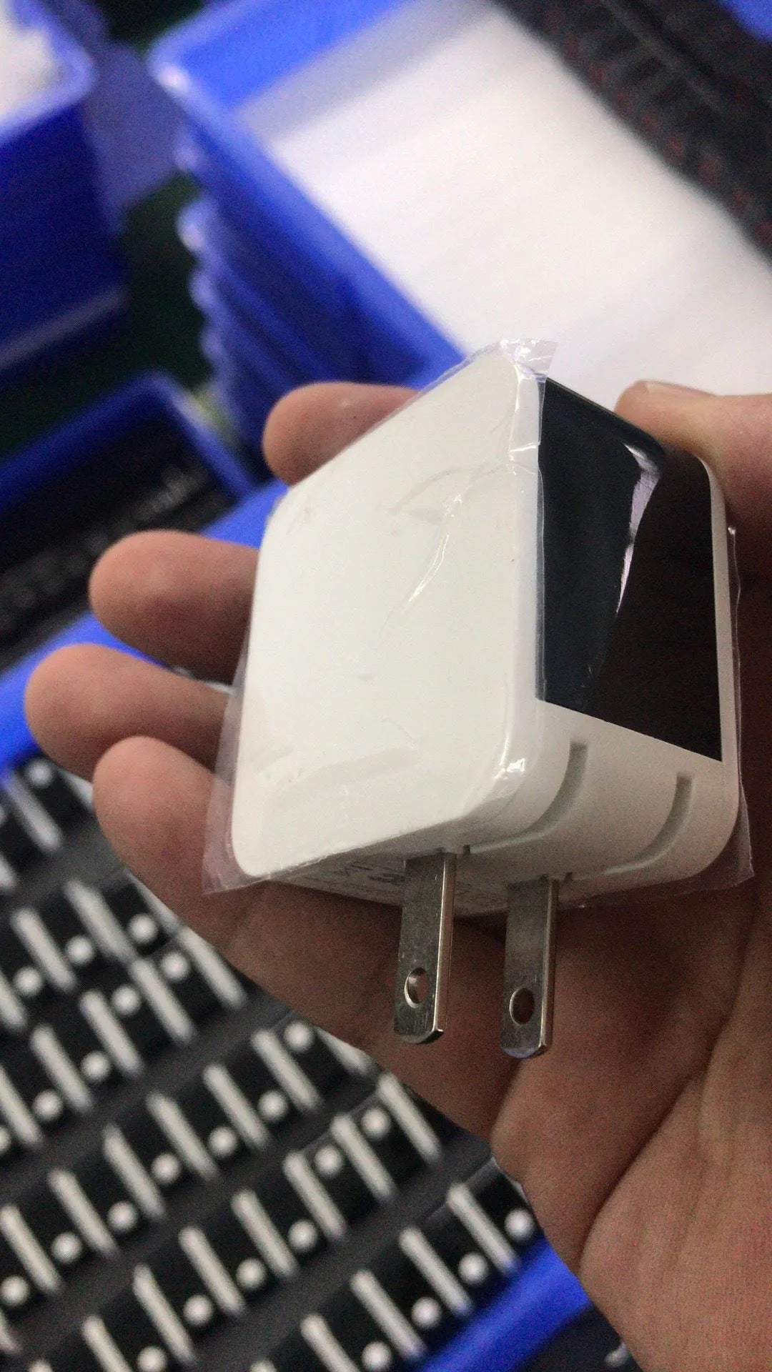 Black and white dual USB travel charger with digital display showing EU and US plug options.