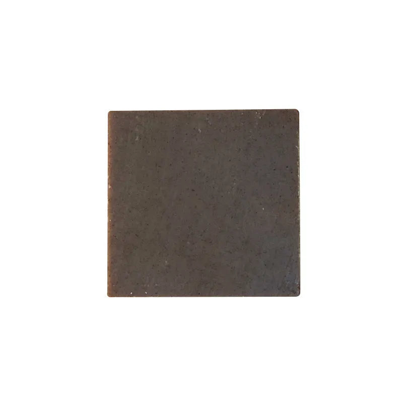 A single 72g round bar of nine herbs cold process shampoo soap on a wooden surface.