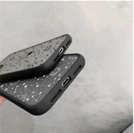 Black anti-blue-light soft-touch iPhone case for multiple models on a table.