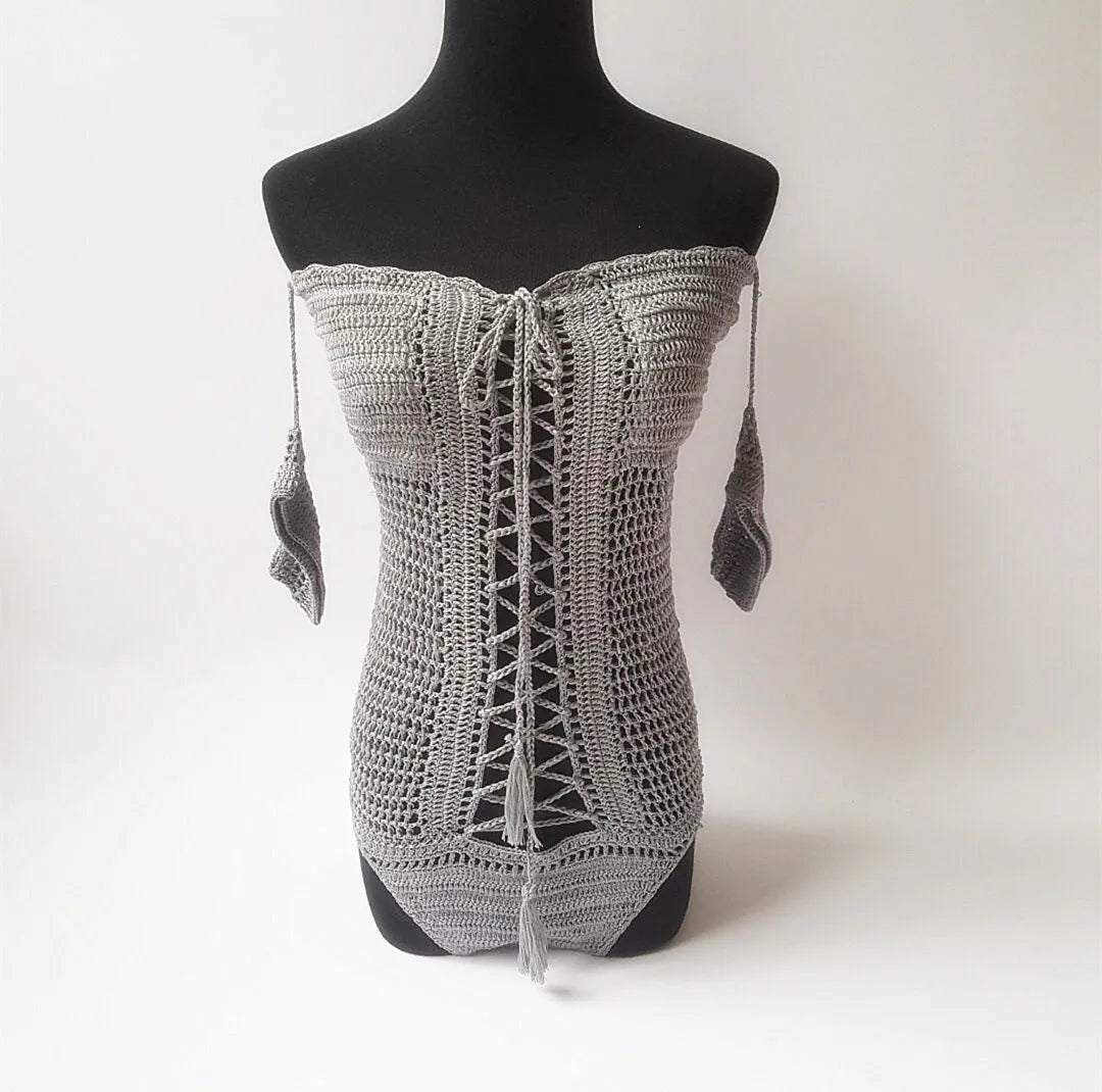 Women's white off-the-shoulder one-piece swimsuit on a mannequin, showing the neckline design.