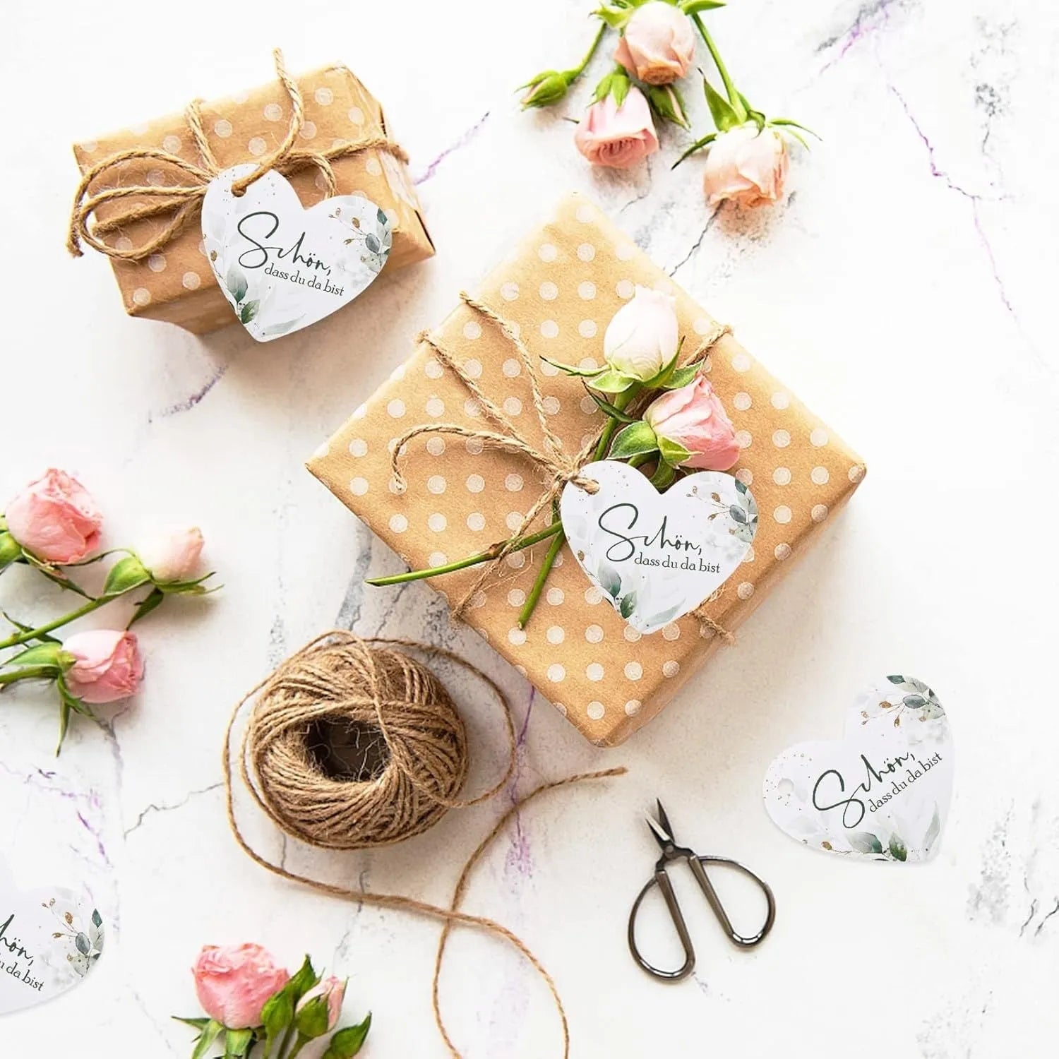 50 flower and heart-shaped paper gift tags in two colour style options, laid out flat.