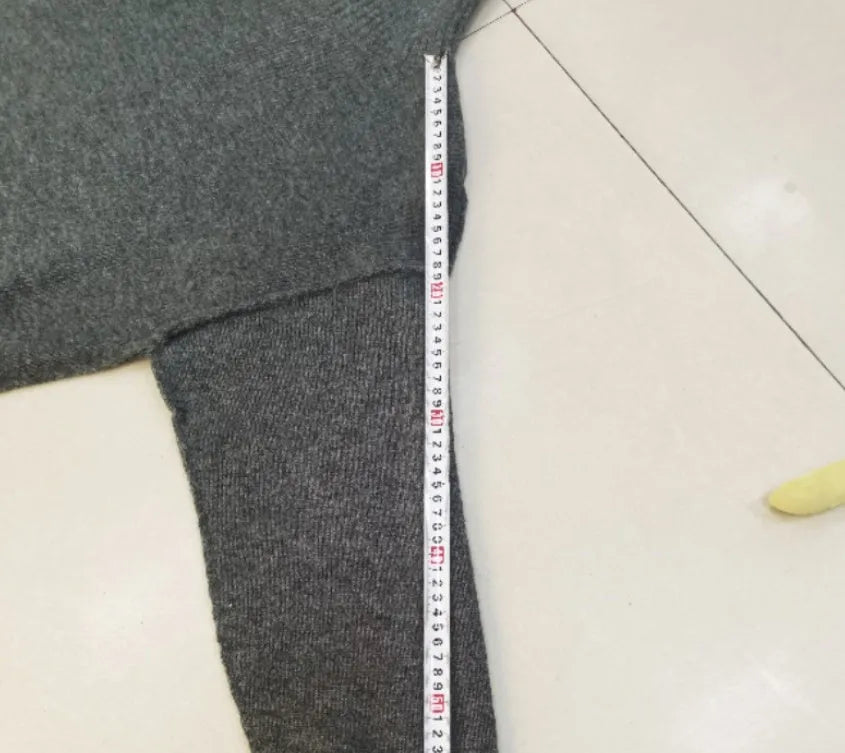 Women's dark grey knit co-ord suit with side-slit sweater and matching trousers laid flat.