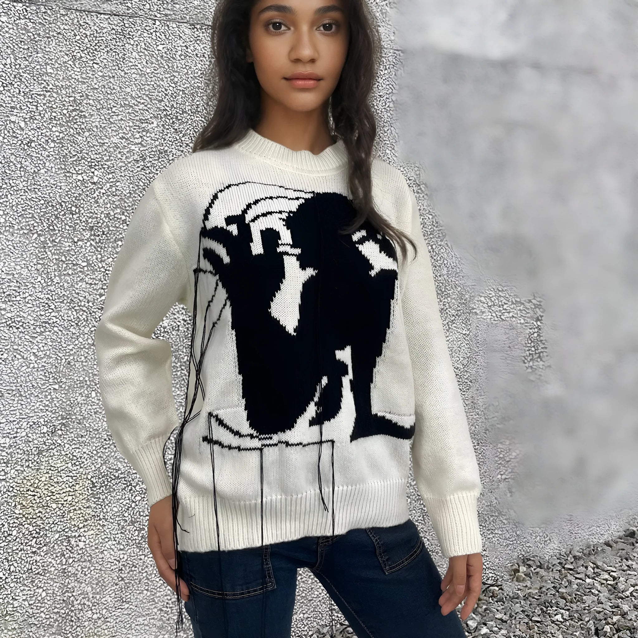 Grey women's alpaca wool pullover sweater with abstract pattern and tassel detailing on a hanger.