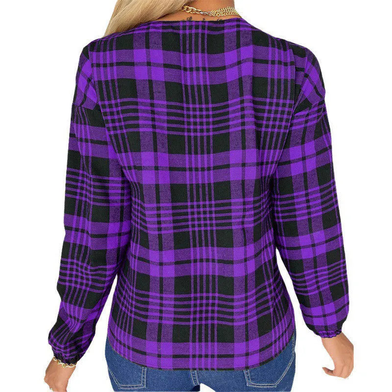 Woman wearing a loose-fitting purple, grey, and red plaid casual shirt with regular sleeves.