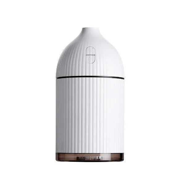 White ultrasonic aromatherapy diffuser and humidifier with LED light on a wooden surface.