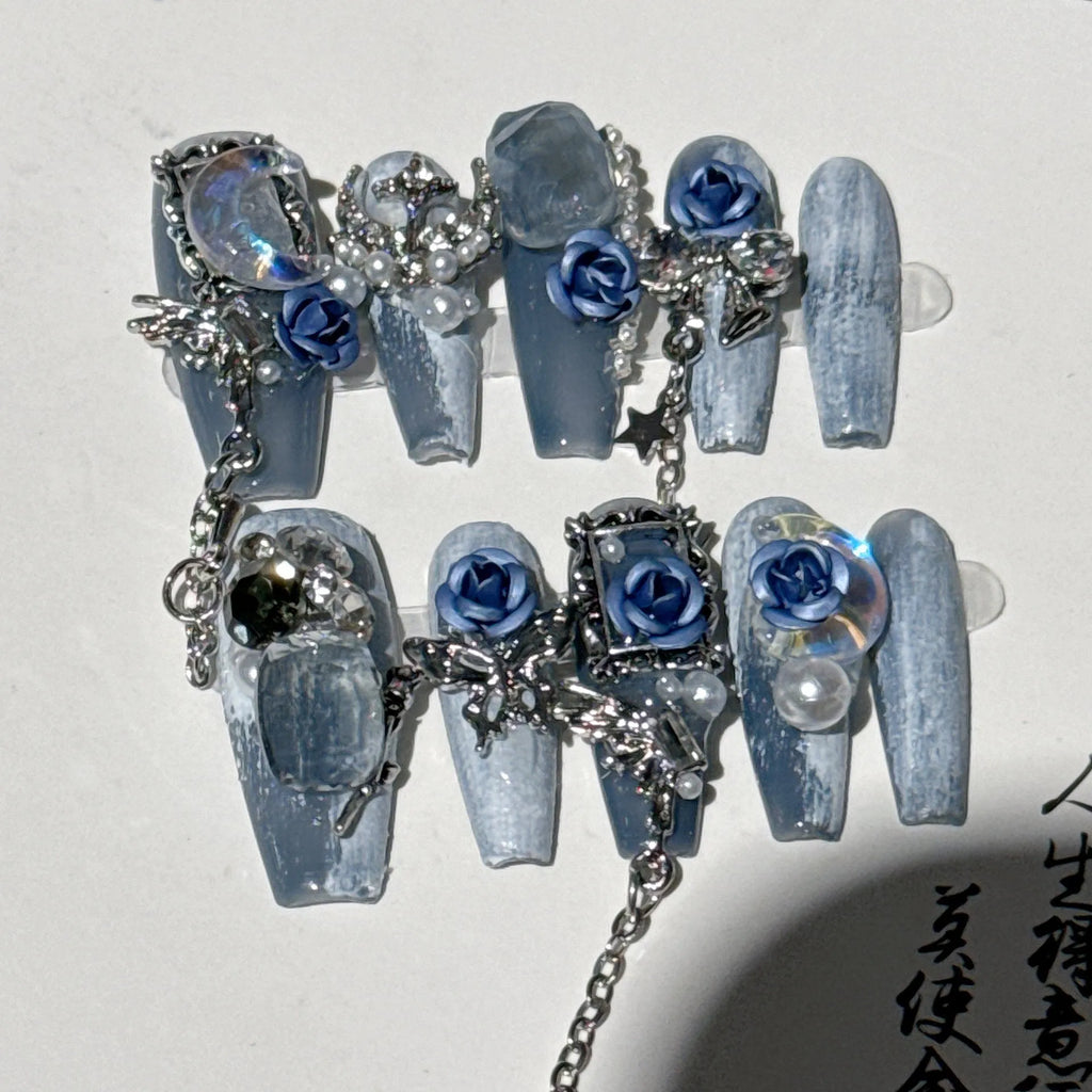 Women's ornate rose floral pattern manicure nails in heavy industry blue colour on a plastic armour suit.