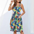 A woman wearing a sleeveless floral printed dress with a short skirt, in a peacock blue colour.