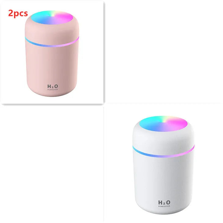 Pink USB mini humidifier with LED lights and water tank on desk