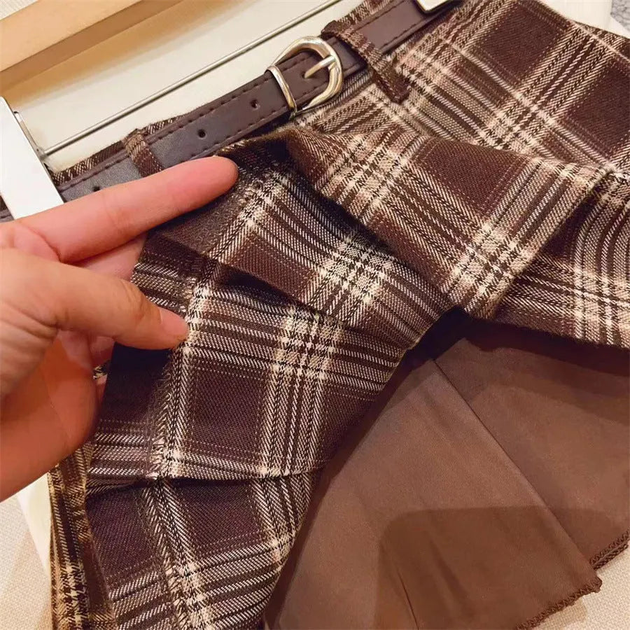 Girls red and black plaid pleated A-line skirt with a cotton lining, shown on a hanger.