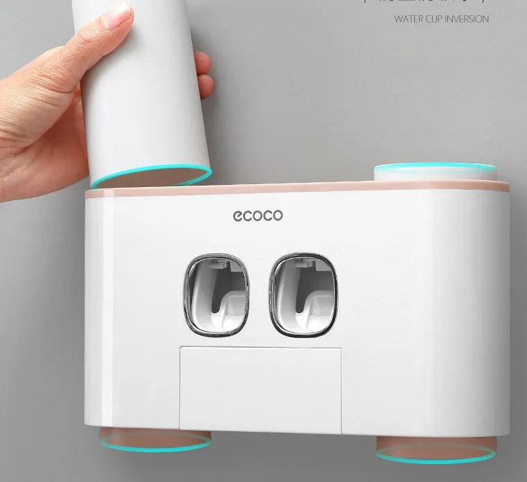 Plastic wall-mounted toothbrush holder with four magnetic cups in pink, blue, and green for family bathroom