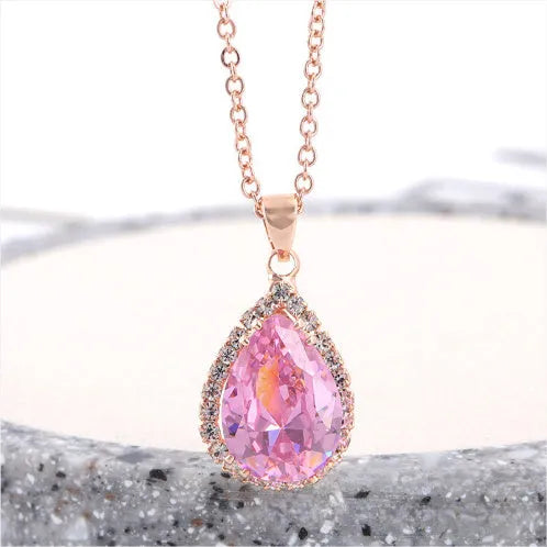 Pink water drop shaped rhinestone necklace with rose gold electroplated alloy pendant on white background