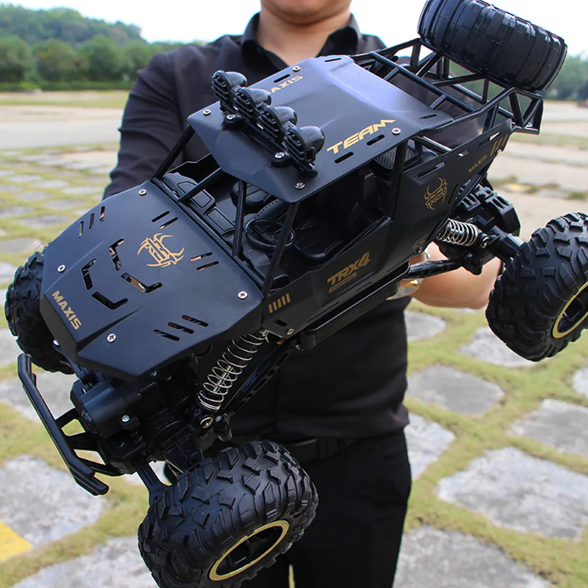 Black and silver remote control climbing cars with 2.4G wireless controller on a rough surface.