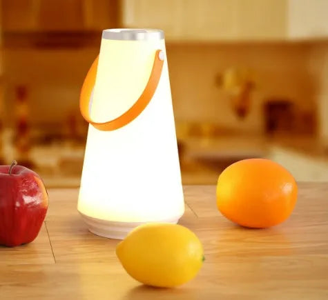 White rechargeable LED bedside night light with adjustable warm glow on wooden table