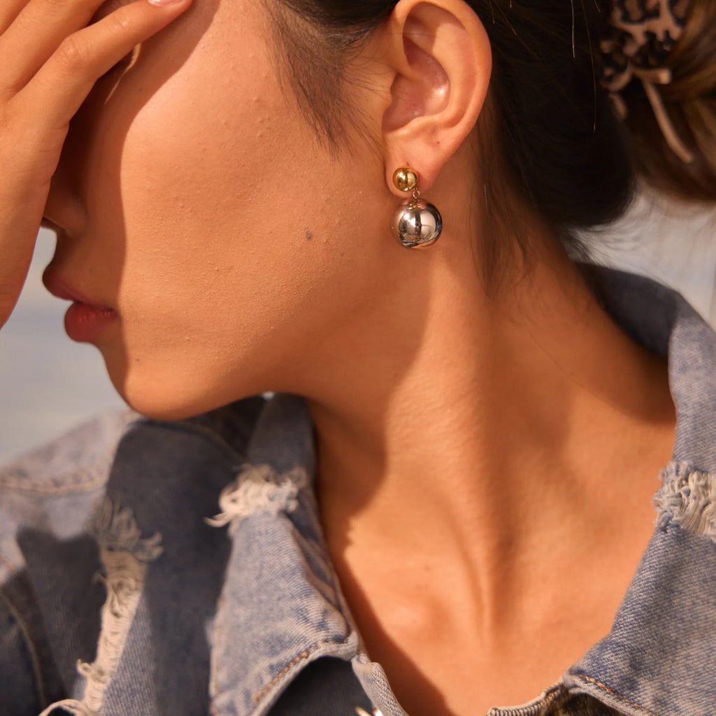 A pair of round bead stainless steel stud earrings with a colour-block geometric design.