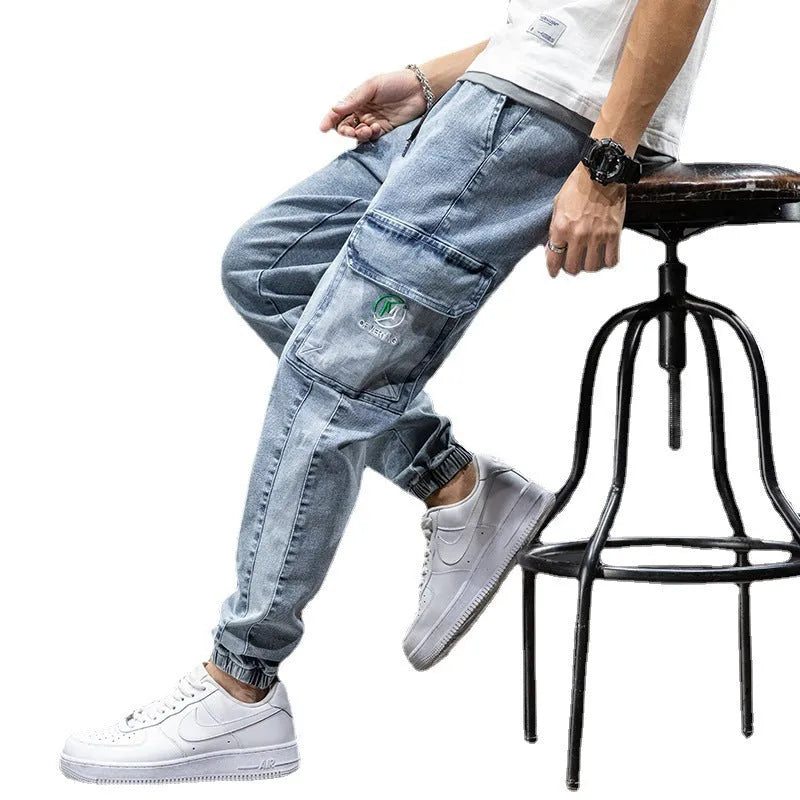 Man wearing loose fit straight leg cargo jeans in blue, showing zipper fly and cargo pocket detail.