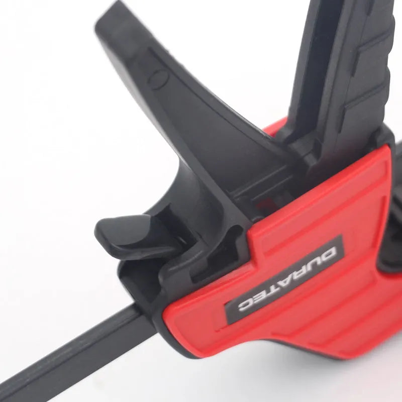 Black plastic woodworking clamp with quick release mechanism and rubber grip jaws