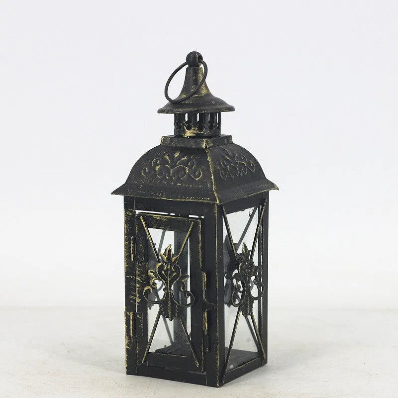 Black wrought iron floor-standing storm lantern with tempered glass panels for outdoor candle lighting