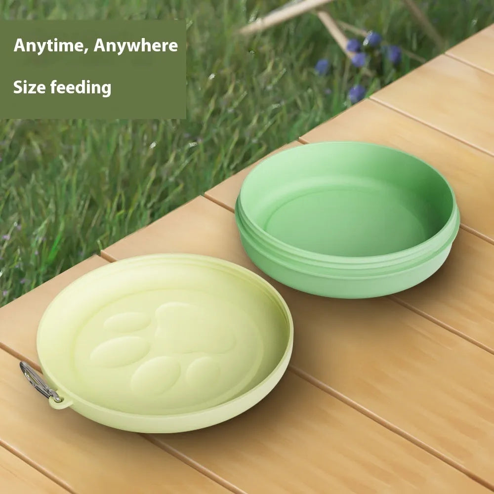 Portable outdoor dog food and water bowl with attached snack box in light pink and green colours.
