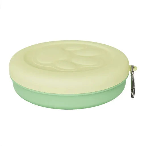 Portable outdoor dog food and water bowl with attached snack box in light pink and green colours.