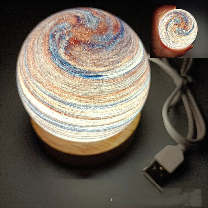 Planets themed USB night light with modern design and three-colour dimming on bedside table.