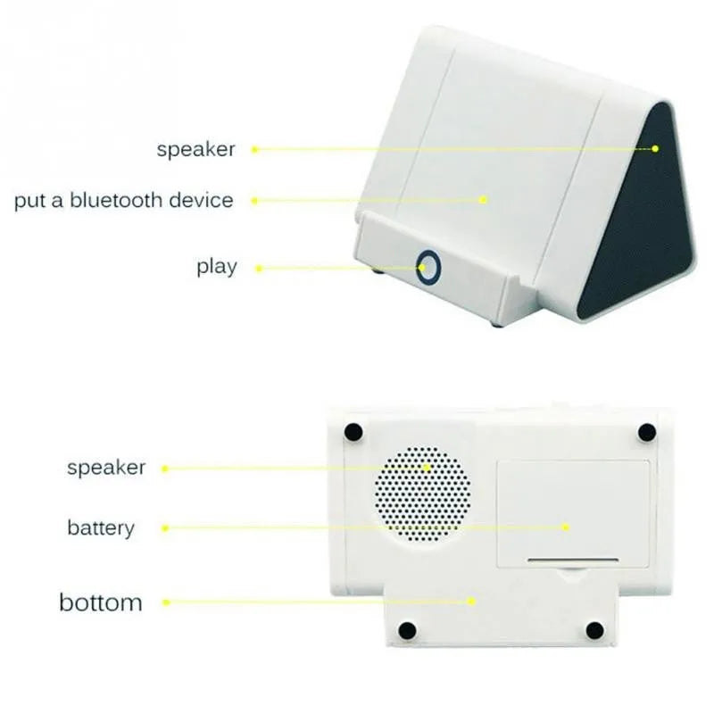 Small black and white wireless Bluetooth speaker with built-in USB charging cable on a desk.