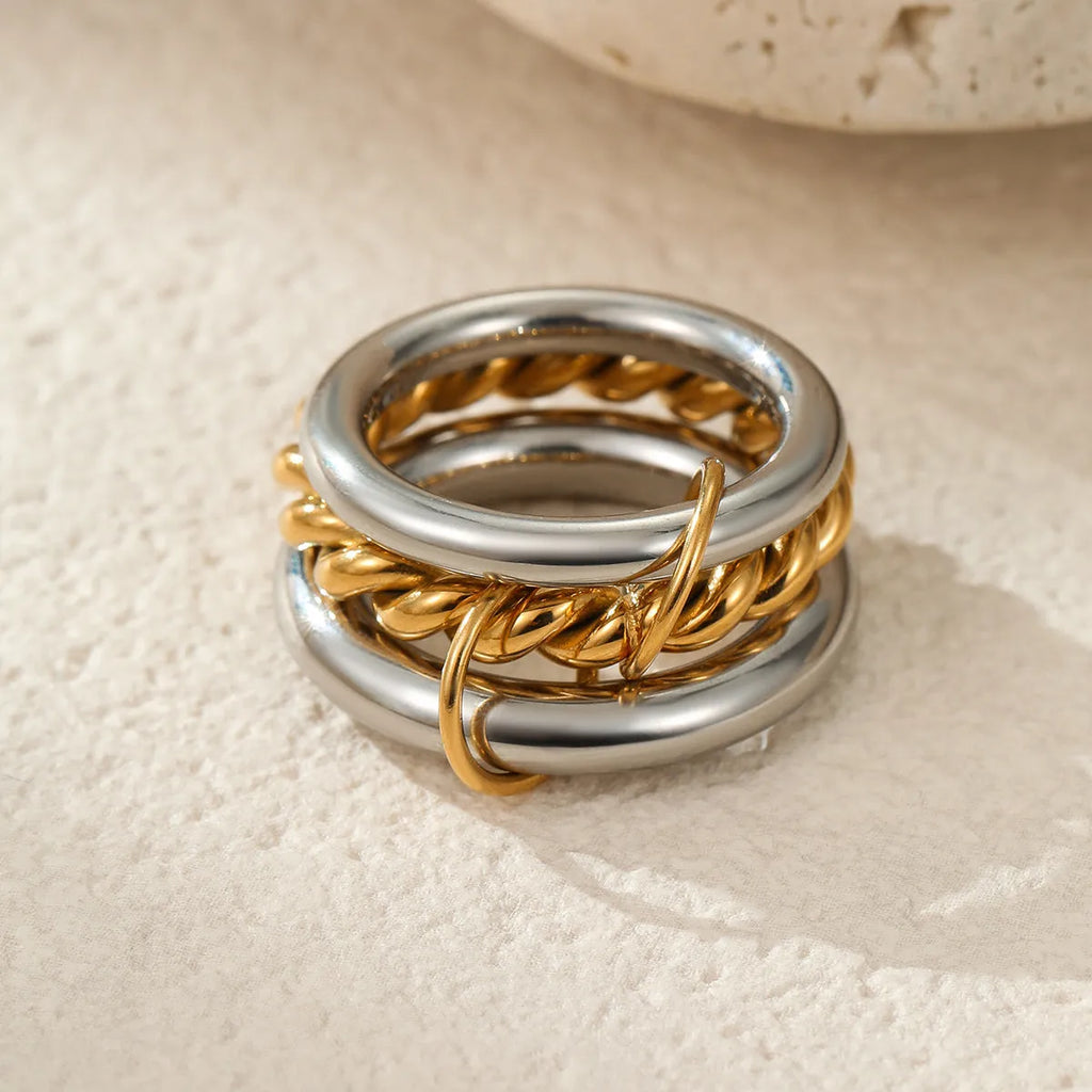 Stacked gold plated stainless steel ring set showing exaggerated design on a model's hand.