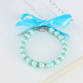 Adjustable diamond dog pearl necklace with rhinestones and ribbon bow in blue, pink, purple, or white.