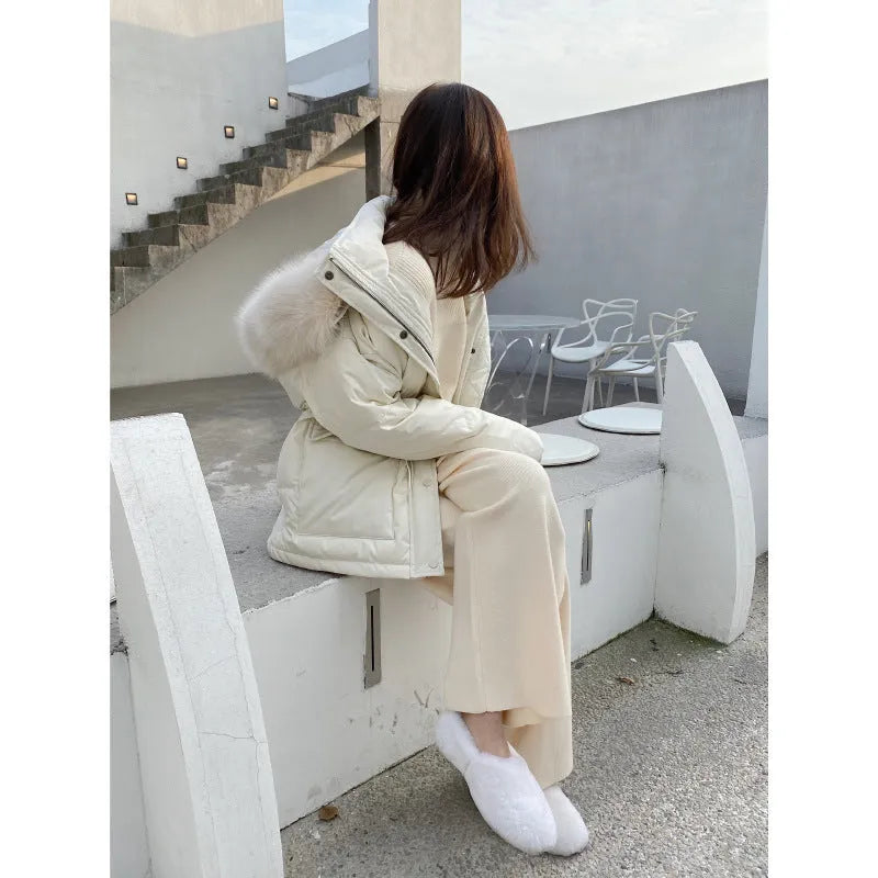 Woman wearing high waist cream white knitted wide-leg trousers with a straight, drooping mopping cut.