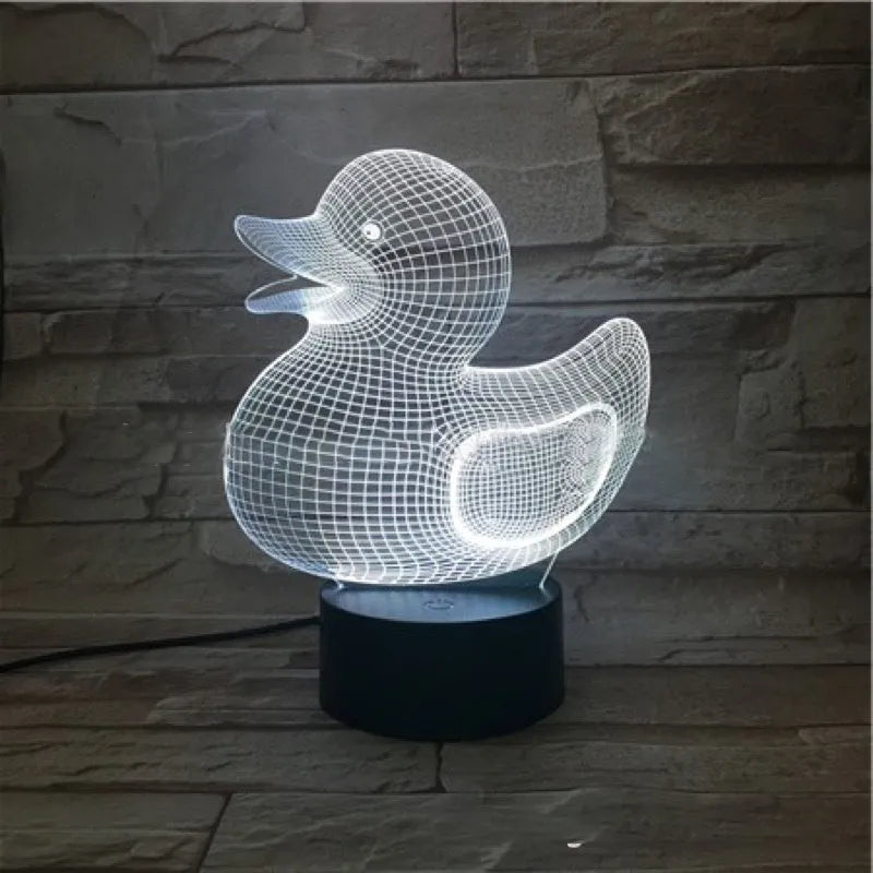 Little Yellow Duck 3D night light showing seven LED colours on a tabletop with remote control.