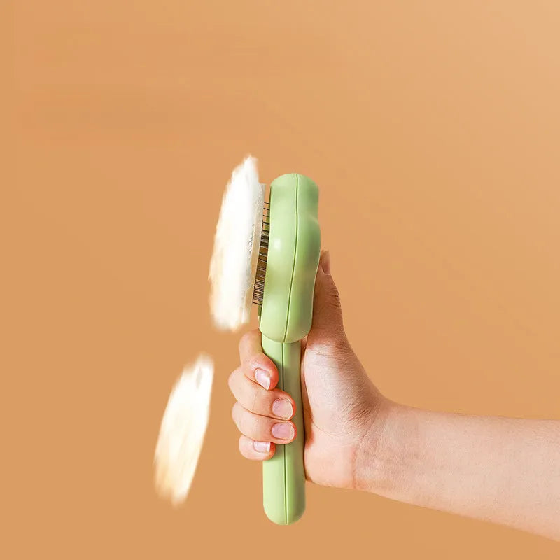 Green self-cleaning stainless steel pet comb with a magic wand handle on a white background.