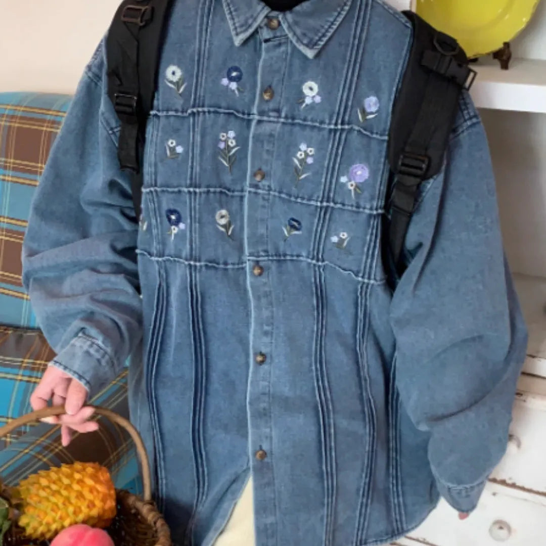 Washed blue denim long sleeve shirt with small floral pleated details on front.