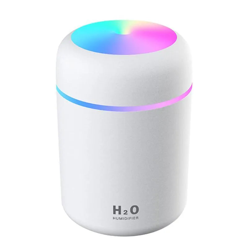 Pink USB mini humidifier with LED lights and water tank on desk